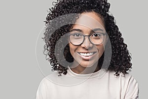 Studio portrait of a beautiful young woman with black curly hair. African american student girl close up, isolated on grey backgro