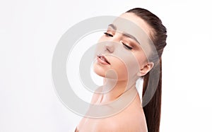 Studio portrait of a beautiful young woman with brown hair. Pretty model girl with perfect fresh clean skin. Beauty