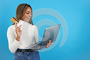 Studio portrait with blue background of a woman buying online.