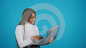 Studio portrait with blue background of a woman buying online.