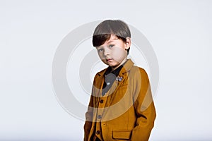 Studio portrait of a boy staring at the camera in a wonderful pose, Casual suit