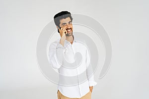 Studio portrait of cheerful young man talking smartphone, having conversation on mobile phone, holding and using