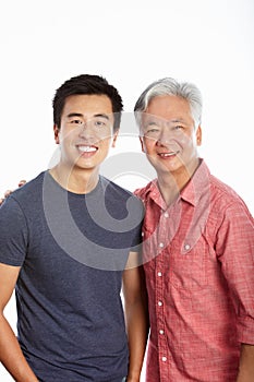 Studio Portrait Of Chinese Father With Adult Son