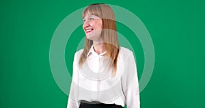 Studio portrait of confident smiling young woman laughing against young woman on a green background in a chroma key