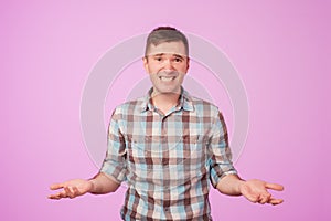 Studio portrait of confused handsome guy showing I have no idea gesture.