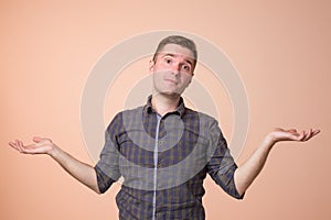 Studio portrait of confused handsome guy showing I have no idea gesture.