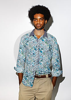 Studio portrait of cool black young man with retro afro hair isolated on white background.