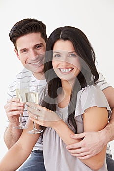 Studio Portrait Of Couple Celebrating With Champagne