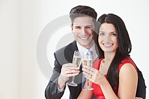 Studio Portrait Of Couple Celebrating With Champagne