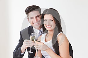 Studio Portrait Of Couple Celebrating With Champagne