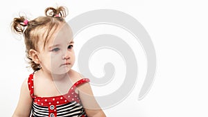 Studio portrait of cute, adorable, sad, upset, crying caucasian toddler girl in dress on isolated white background
