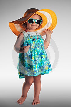 Studio portrait of cute baby girl with hat and sunglasses, summer concept