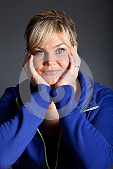 Studio portrait of a cute blond girl bored with heads in hands