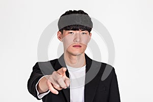 A studio portrait of an East Asian business man pointing at something