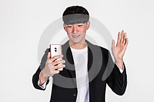 A studio portrait of an East Asian business man posing for various poses with a cellphone