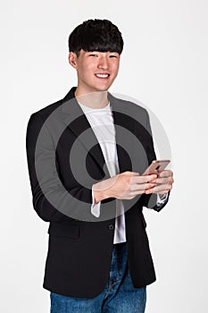 A studio portrait of an East Asian business man posing for various poses with a cellphone