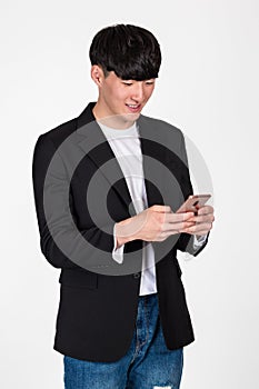 A studio portrait of an East Asian business man posing for various poses with a cellphone