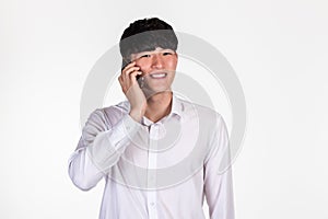 A studio portrait of an East Asian business man posing for various poses with a cellphone