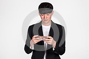 A studio portrait of an East Asian business man posing for various poses with a cellphone