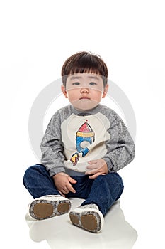 Studio portrait of an East Asian young child with a serious look on a white background