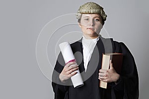 Studio Portrait Of Female Lawyer Holding Brief And Book