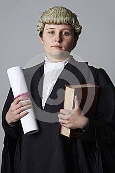 Studio Portrait Of Female Lawyer Holding Brief And Book