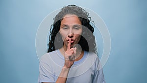 Studio portrait female model Latino girl Hispanic Indian Arabian woman showing hush lips gesture silence secret quiet