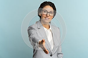 Friendly hospitable cheerful business woman or office worker wear blazer giving hand to handshake