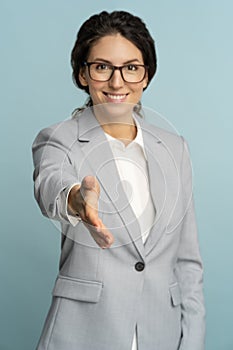 Friendly hospitable cheerful business woman or office worker wear blazer giving hand to handshake