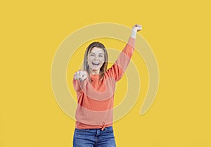 Studio portrait of a funny cheerful beautiful young woman dancing like a cowgirl