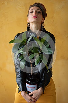 Studio portrait of glamorous lady in punk rock style party clothes with dark pink mohawk in casual dress, black leather