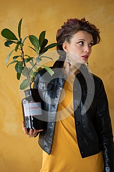 Studio portrait of glamorous lady in punk rock style party clothes with dark pink mohawk in casual dress, black leather