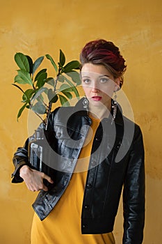 Studio portrait of glamorous lady in punk rock style party clothes with dark pink mohawk in casual dress, black leather