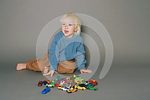 Studio portrait on grey background of adorable little boy
