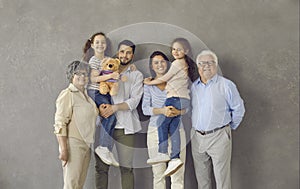 Studio portrait of happy mom, dad, kids and grandparents standing together and smiling