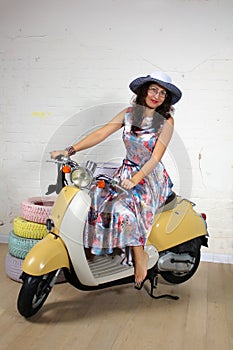 Studio portrait of a happy young asian woman on scooter
