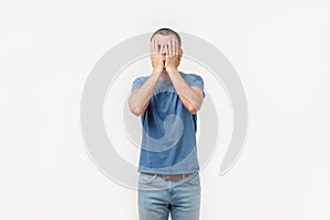 Studio portrait of hidpanic young man covering his face in dissapoint using facepalm sign