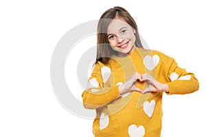 Studio portrait of a little girl on white background making a heart gesture with her hands. Fostering a child. photo