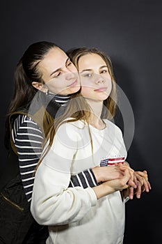 Studio portrait of a loving mother and daughter, tenderly and strongly hugging and holding hands