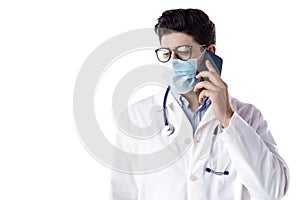 Studio portrait of male doctor talking with sombody on his mobile phone while standing at isolated white background