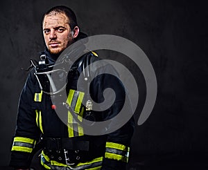 Studio portrait of a male dressed in a firefighter uniform.