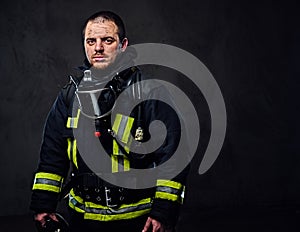 Studio portrait of a male dressed in a firefighter uniform.