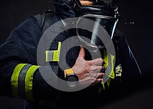 Studio portrait of a male dressed in a firefighter uniform.