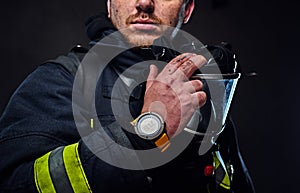 Studio portrait of a male dressed in a firefighter uniform.
