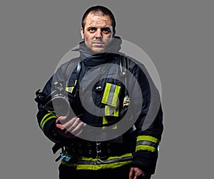 Studio portrait of a male dressed in a firefighter uniform.