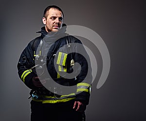 Studio portrait of a male dressed in a firefighter uniform.