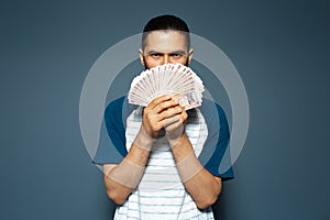 Studio portrait of man, holding money on face, bunch of banknotes, Moldovan leu.