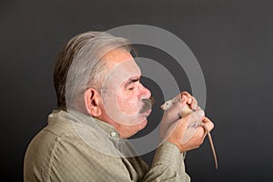 Studio portrait of a man with a white rat