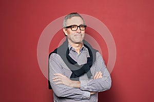 Studio portrait of mature businessman on red background