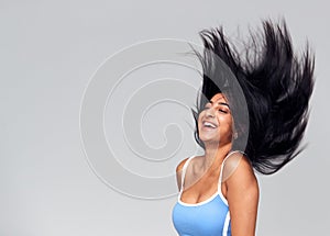 Studio Portrait Of Positive Happy Young Woman Flicking Long Hair